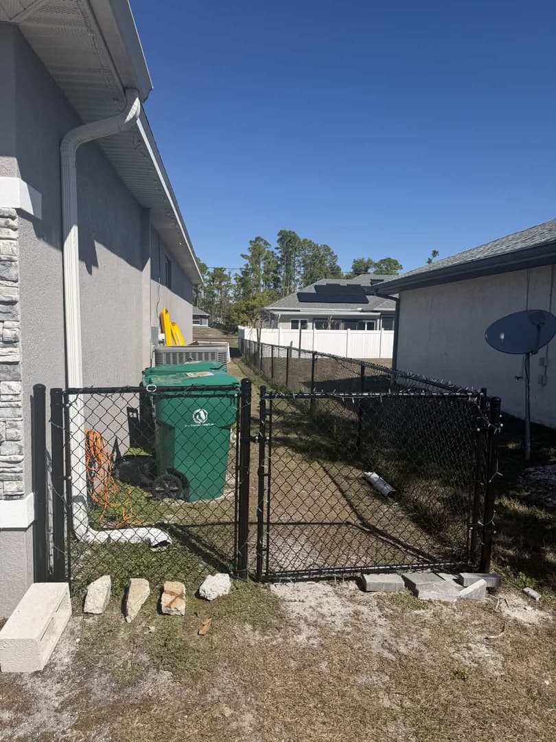 Black vinyl-coated chain link fence with gate installation