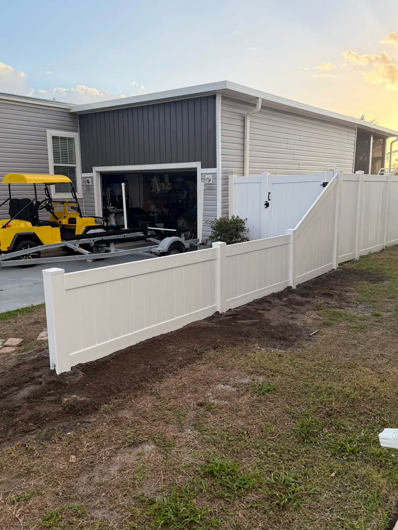 White vinyl fence with gate installed at residential home